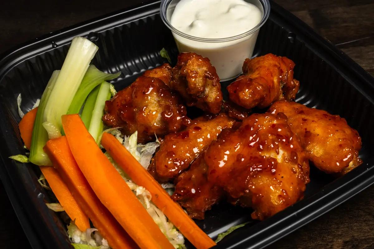 Sauced buffalo wings with carrots, celery and dipping sauce